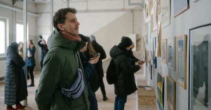 Besucher betrachtet die Ausstellung von Anatoli Budjko